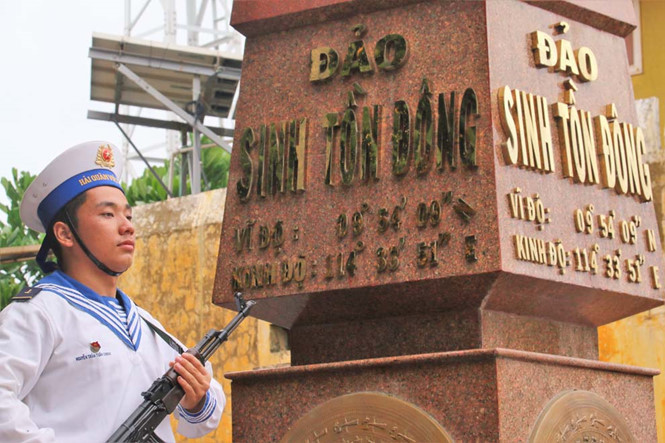 Hạ sĩ Nguyễn Trần Tuấn Khanh gác bên mốc chủ quyền đảo Sinh Tồn Đông.