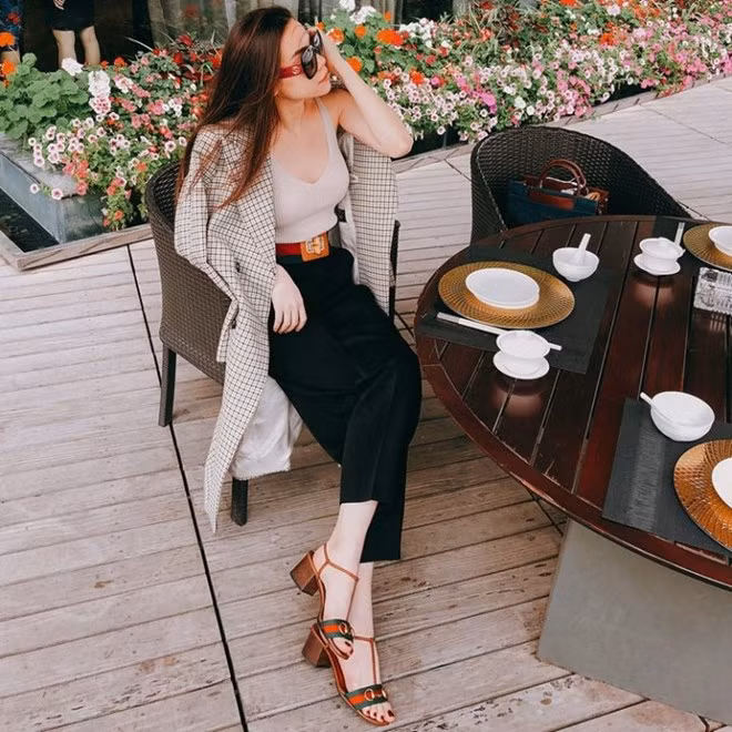 Hồ Ngọc Hà kết hợp ăn ý áo tank ôm sát và quần ống suông, phối màu đen trắng hơi hướm tối giản. Nữ ca sỹ nhấn vẻ sang trọng bằng mẫu áo khoác kẻ ô vuông, chọn mắt kính, thắt lưng và sandals đều của Gucci tô đậm phong cách thời thượng.