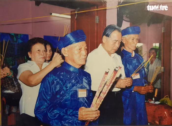 Ông Sáu Khải cùng các bậc cao niên trong làng thắp nhang trong một lần cúng đình - Ảnh: Chụp lại từ tư liệu đình Tân Thông
