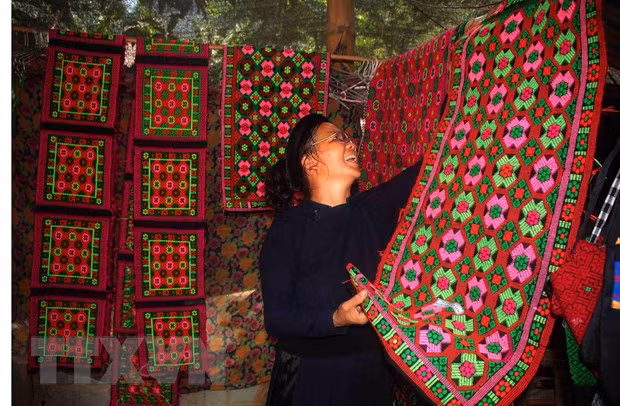 Nghệ nhân Nông Thị Thược (Cao Bằng) với các sản phẩm dệt thổ cẩm truyền thống. (Ảnh: Chu Hiệu/TTXVN)