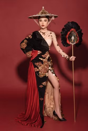 Được thiết kế với tông màu chủ đạo là đen, vàng đồng và đỏ, bộ trang phục mang tới sự sang trọng, quyền quý và mạnh mẽ cho người mặc. Tông đỏ không chỉ trở thành điểm nhấn mà theo quan niệm của người Á đông nó còn mang ý nghĩa may mắn.