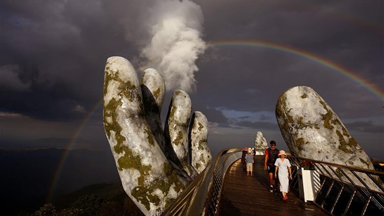 May mắn hơn Jason, nhà báo Huy Khâm lại sở hữu bức ảnh Cầu Vàng độc đáo, ấn tượng mê hồn trong ánh Cầu Vồng đăng trên Reuters. Tác giả cho biết, để sở hữu bức ảnh có một không hai này anh đã phải dày công quan sát và chờ đợi cả một ngày dài để săn được khoảnh khắc vi diệu của thiên nhiên. Đây là bức ảnh chụp ngay sau khi cơn mưa buổi chiều vừa dứt. Mây và cầu vồng bất ngờ xuất hiện tạo nên quầng sáng kỳ ảo bao bọc lấy bàn tay khổng lồ