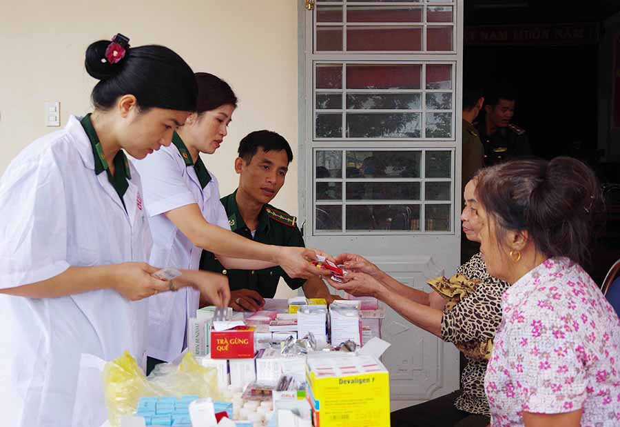  Các y-bác sĩ tận tình hướng dẫn người dân sử dụng thuốc đúng liều. Ảnh: A.H