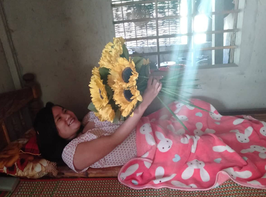 Tay yếu nhưng em vẫn nỗ lực hết sức mình để làm ra những bông hoa giấy – công việc duy nhất em có thể kiếm chút thu nhập giúp ba mẹ.