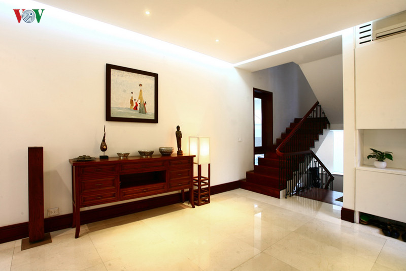 Chiếc tủ trang trí kiểu bàn console ở thẳng lối cửa vào, cùng với tranh, tượng theo lối cổ điển trên một nền hiện đại.