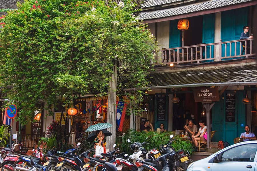 Phố nhỏ Luang Prabang nhiều xe máy không kém Việt Nam, nhưng không hiểu sao vẫn rất yên tĩnh. Các quán cafe đầy khách Tây ngồi trò chuyện sau tán hoa giấy buông rủ