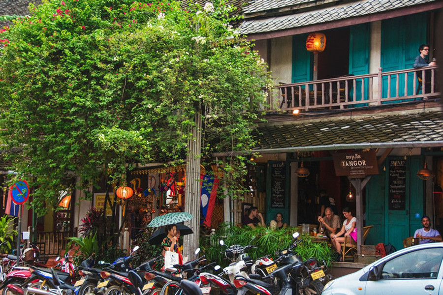 Phố nhỏ Luang Prabang nhiều xe máy không kém Việt Nam, nhưng không hiểu sao vẫn rất yên tĩnh. Các quán cafe đầy khách Tây ngồi trò chuyện sau tán hoa giấy buông rủ