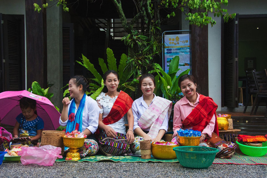  Các cô gái Lào dậy từ rất sớm để chuẩn bị cho lễ cúng dường, nở nụ cười thật tươi với du khách ghé qua