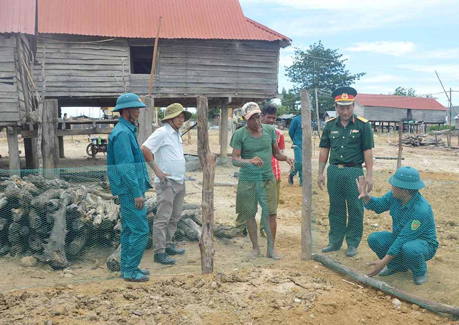  Lực lượng vũ trang huyện Phú Thiện hướng dẫn người dân làng Trớ, xã Chư A Thai làm hàng rào vườn rau. Ảnh: P.D