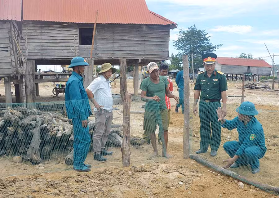  Lực lượng vũ trang huyện Phú Thiện hướng dẫn người dân làng Trớ, xã Chư A Thai làm hàng rào vườn rau. Ảnh: P.D