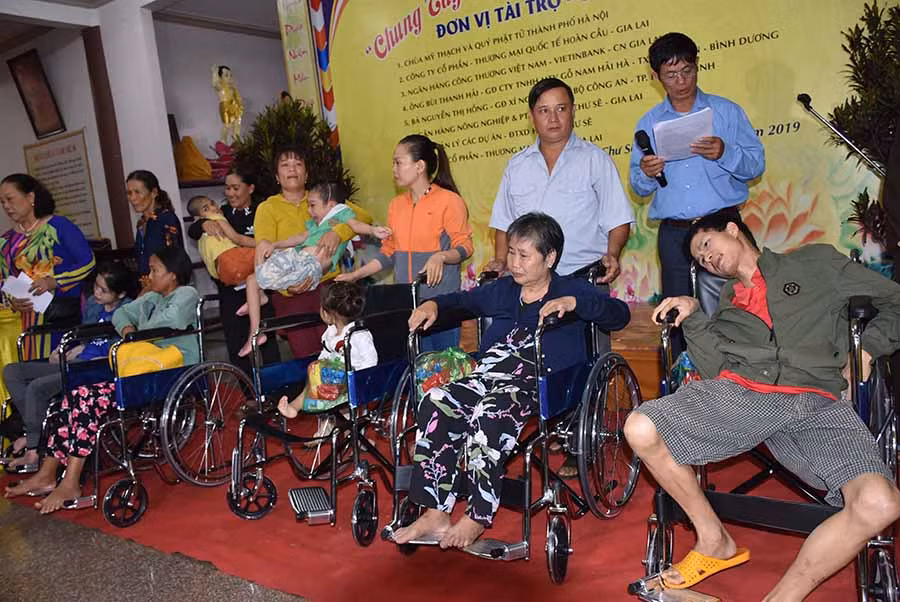  Tặng xe lăn cho các gia đình NNCĐDC/dioxin. Ảnh: H.P