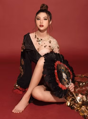 Đặc biệt, chiếc quạt lông cán đứng dài cũng là một phụ kiện đáng chú ý. Phần lông được làm từ lông ngỗng, gắn thêm lông công kết hợp với một số hạt đá thể hiện sự quyền quý.