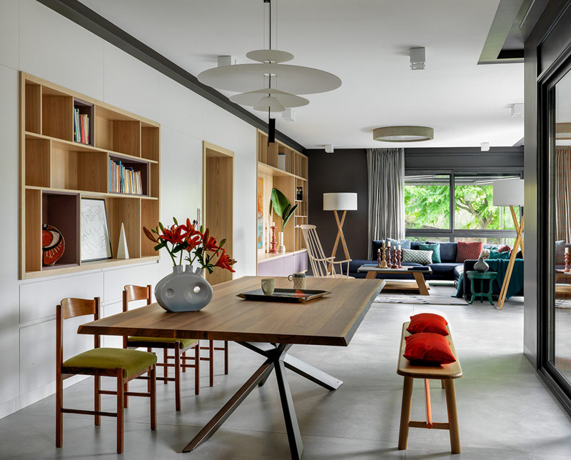 Căn phòng có bộ bàn ăn được kê sát với giá sách. Phía trước là bộ bàn ghế sofa dành cho việc tiếp khách. Nhìn toàn thể nhà ở trông rất thoáng đãng, gọn gàng. 