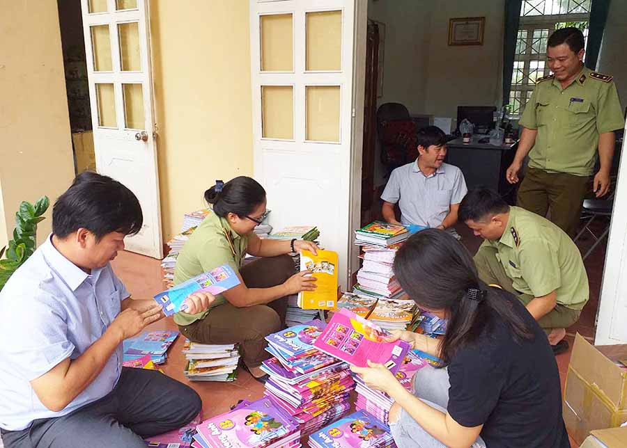  Lực lượng Quản lý Thị trường kiểm đếm số lượng sách giả. Ảnh: A.H