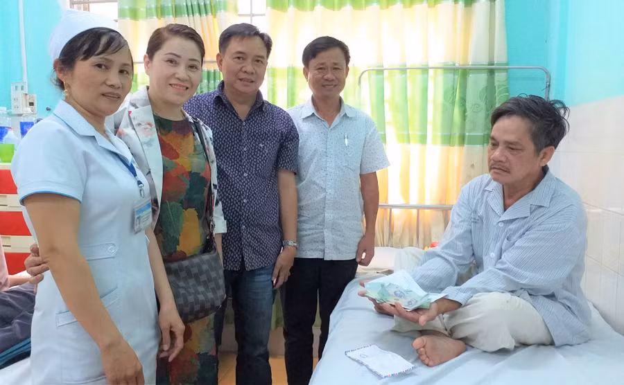 Đại diện Hội đồng hương họ Dương tỉnh Gia Lai trao tiền hỗ trợ cho anh Dương Ngọc Ánh. Ảnh: Đinh Yến 