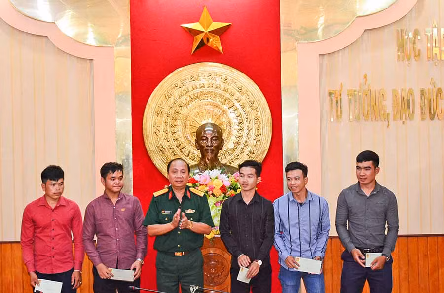 Đại tá Lê Xuân Phương, Phó tư lệnh-Tham mưu trưởng Binh đoàn 15 tặng quà cho 5 sinh viên Lào. Ảnh: Sơn Tùng