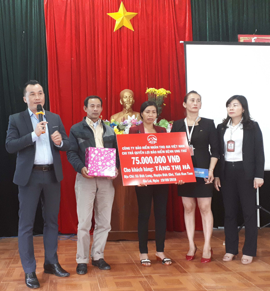 Đại diện Công ty bảo hiểm AIA Việt Nam chi trả quyền lợi bảo hiểm cho khách hàng. Ảnh: Nam An