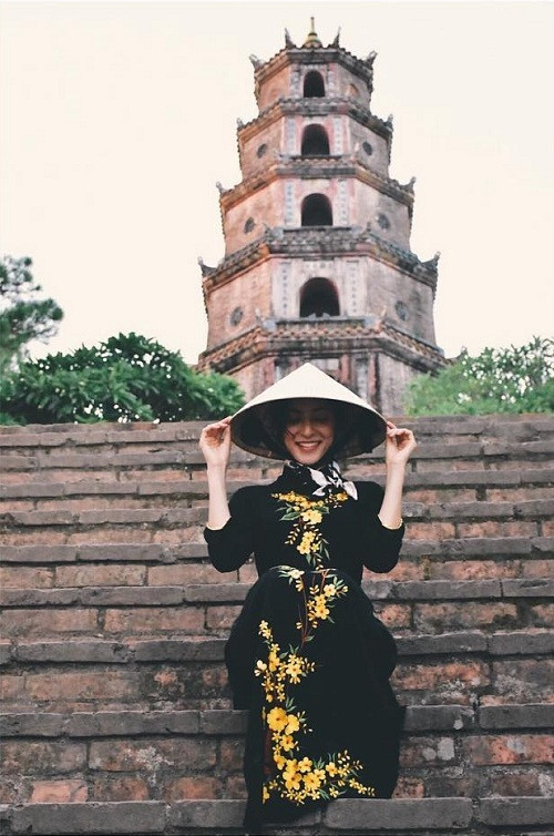 Trước đó, nữ diễn viên dừng chân ở Huế. Cô mặc áo dài sẫm màu thêu hoa vàng nổi bật khi vãn cảnh chùa Thiên Mụ.