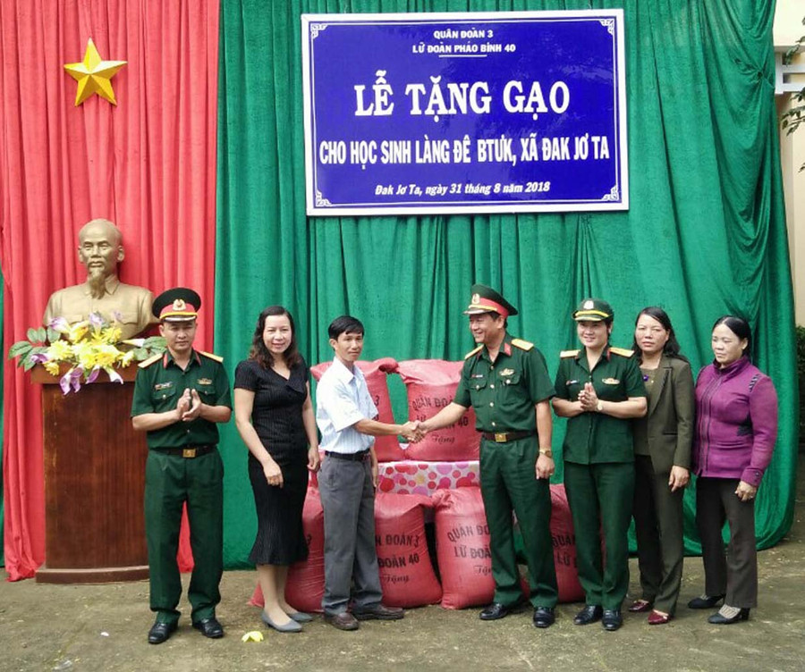 Lãnh đạo Lữ đoàn Pháo binh 40 trao gạo cho lãnh đạo Trường Tiểu học và THCS Đak Jơ Ta. Ảnh: Hà PhươngP
