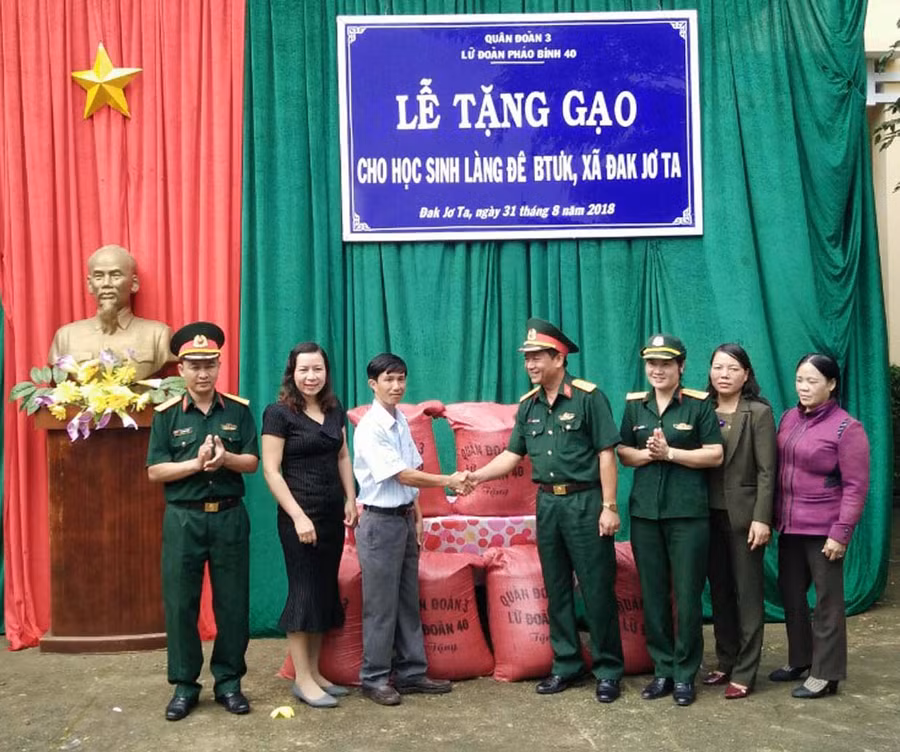 Lãnh đạo Lữ đoàn Pháo binh 40 trao gạo cho lãnh đạo Trường Tiểu học và THCS Đak Jơ Ta. Ảnh: Hà PhươngP