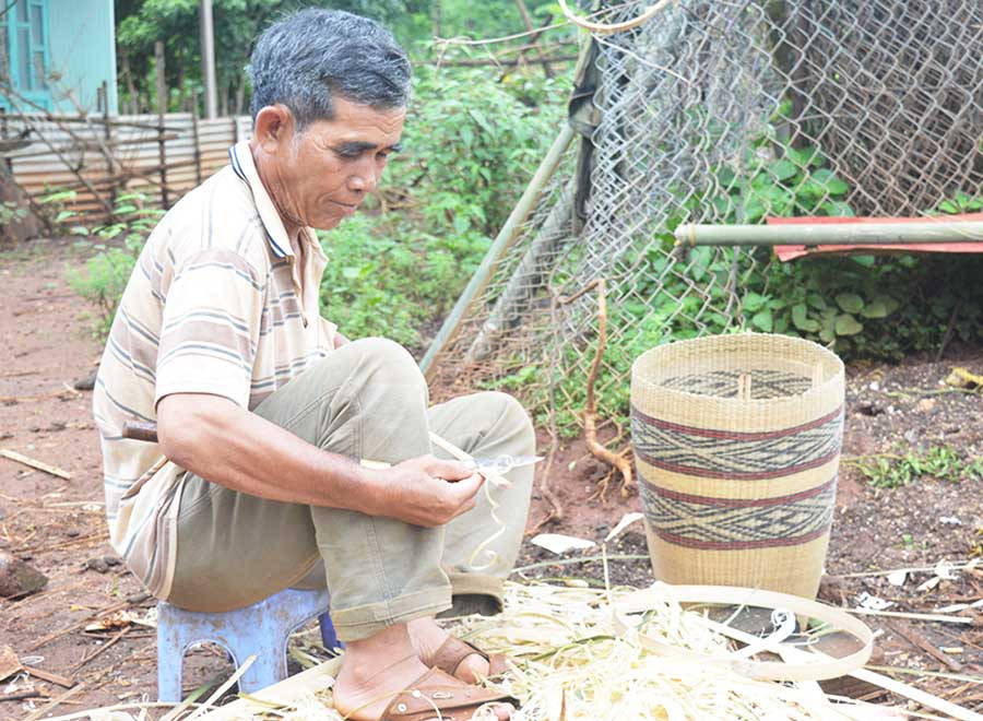  Ông Rơ Mah Thế tranh thủ thời gian rảnh rỗi để đan gùi. Ảnh: P.D