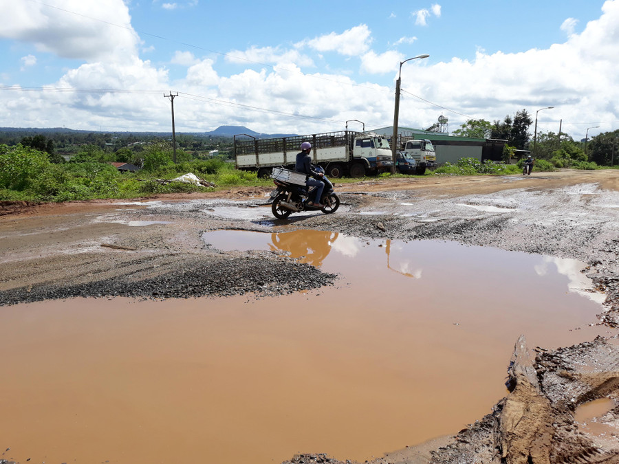 Người dân khó khăn luồn lách qua những hố bom khá sâu. Ảnh: Q.T