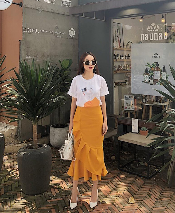  Chân váy xếp khối bắt mắt lại được Yến Trang sử dụng cùng kiểu áo thun in hoạ tiết pop art. Công thức phối đồ này giúp cô thể hiện tinh thần trẻ trung, năng động.