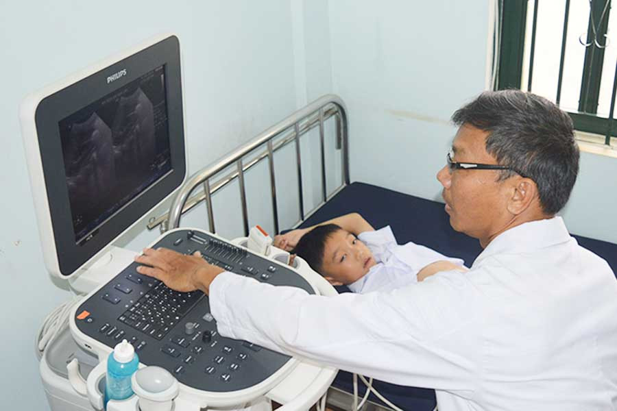  Bác sĩ Đào Phú Yên đang siêu âm cho một bệnh nhi. Ảnh: Phương Dung