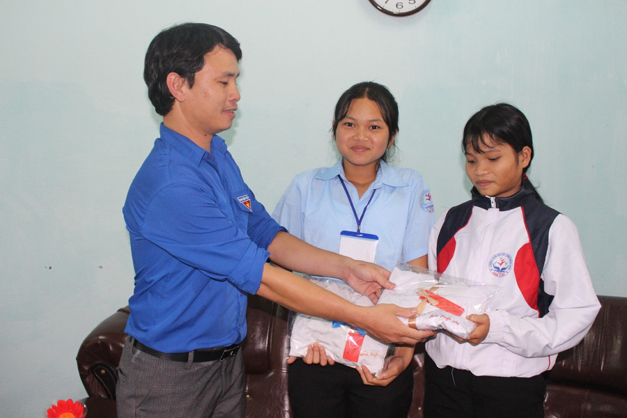  Thầy Phạm Văn Nguyên-Bí thư Đoàn trường THPT Trường Chinh-trao quà của các nhà hảo tâm cho học sinh có hoàn cảnh đặc biệt khó khăn. Ảnh: N.G