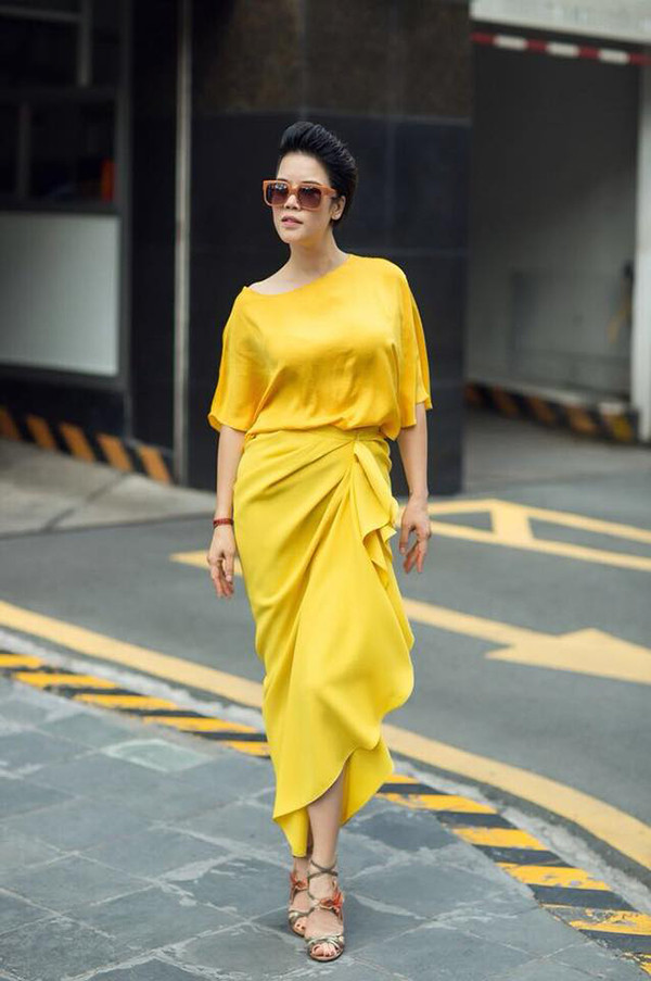 Thu Phương nổi bật trên phố với set đồ mang tông màu của nắng. Áo lụa dáng rộng được ca sĩ kết hợp cùng chân váy xếp nếp đồng màu.