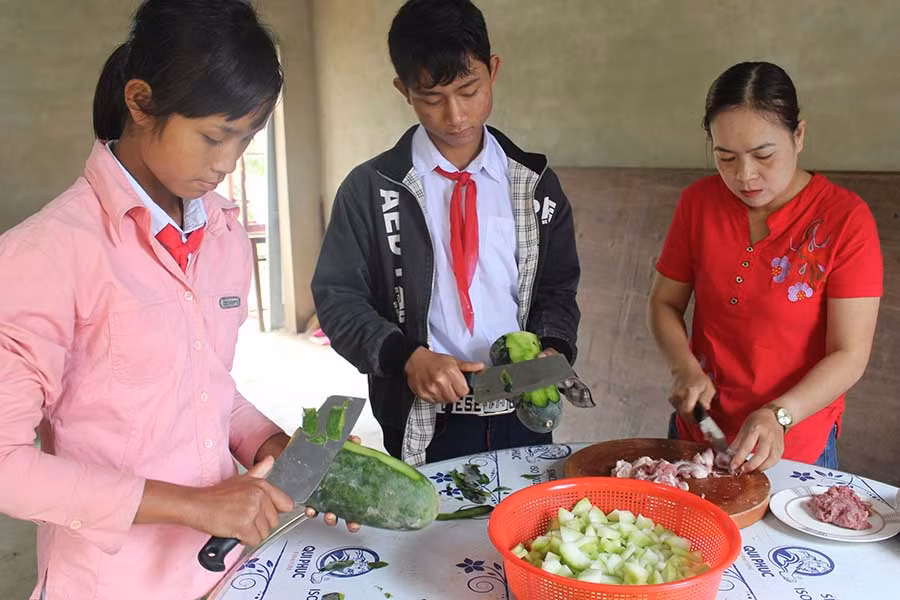  Học sinh bán trú Trường Tiểu học và THCS Đak Jơ Ta phụ các cô nấu ăn trong giờ ra chơi. Ảnh: N.G