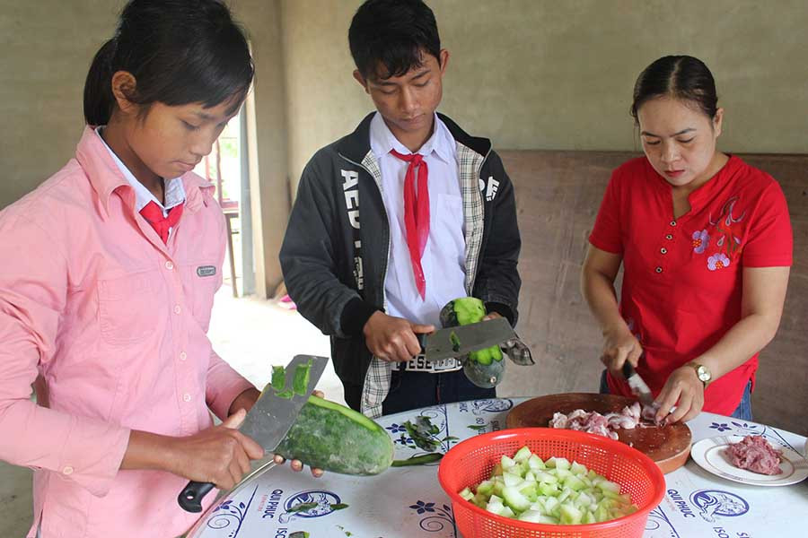  Học sinh bán trú Trường Tiểu học và THCS Đak Jơ Ta phụ các cô nấu ăn trong giờ ra chơi. Ảnh: N.G