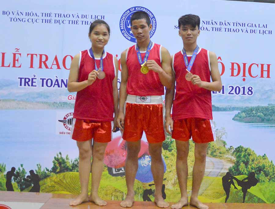 VĐV Rơ Chăm Độ (giữa) trên bục nhận HCV tại Giải Vô địch trẻ toàn quốc Kick boxing 2018. Ảnh: Minh Vỹ