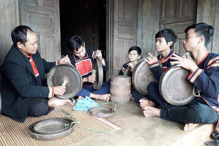  Nghệ nhân Siu Cheng (bìa trái) dạy thanh-thiếu niên trong làng cách đánh cồng chiêng. Ảnh: H.T