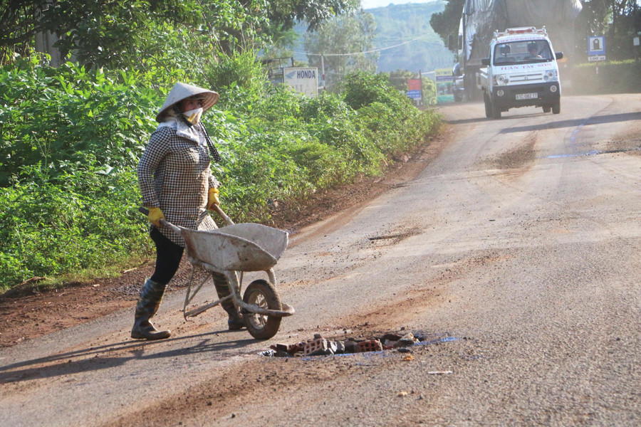 Người dân phải tự vá tạm thười những hố sâu để hạn chế nguy hiểm cho gia đình và người đi đường. Ảnh: Q.T