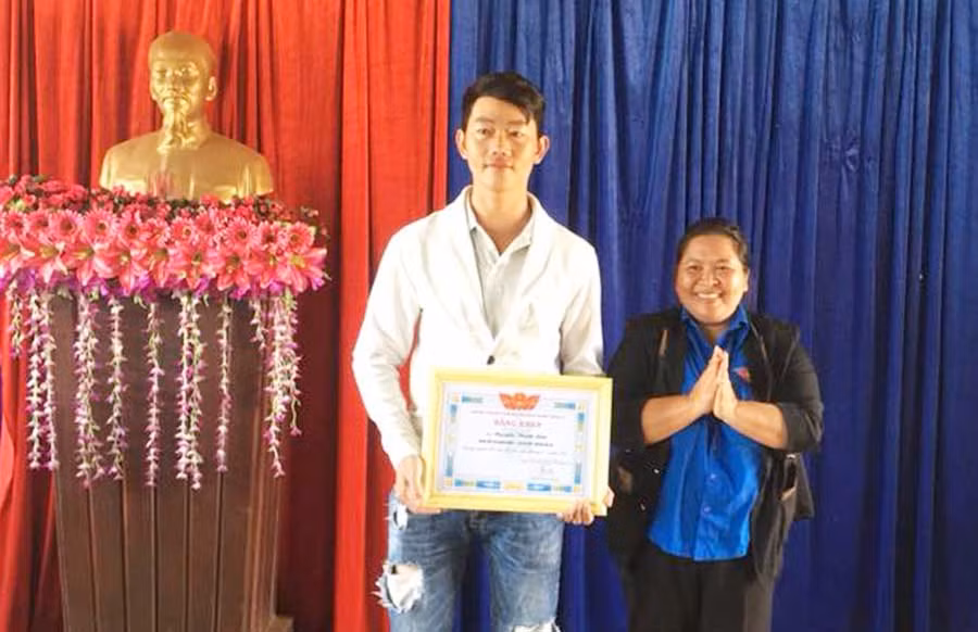 Chị Hà Thị Giang Thảo trao thưởng cho anh Nguyễn Thanh Lâm gương Người tốt tháng 8. Ảnh: H’Yuên
