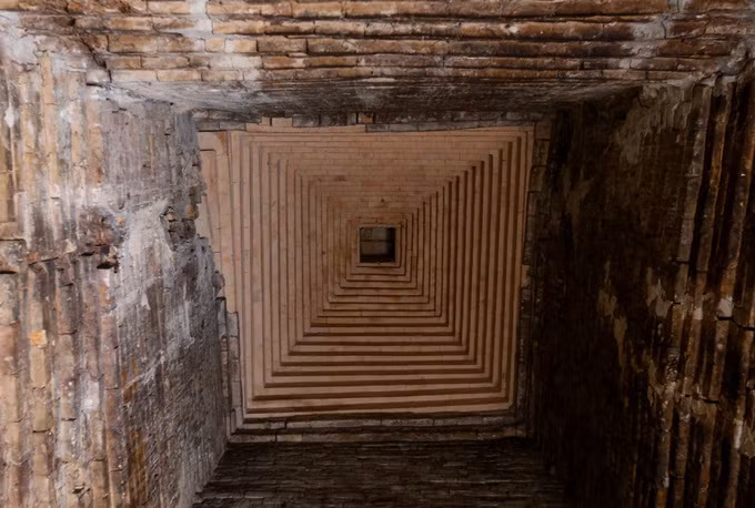 Kiến trúc phía trên tầng mái nhìn từ bên trong tháp với những viên gạch được xây theo hình vuông, chụm lại ở đỉnh tháp.