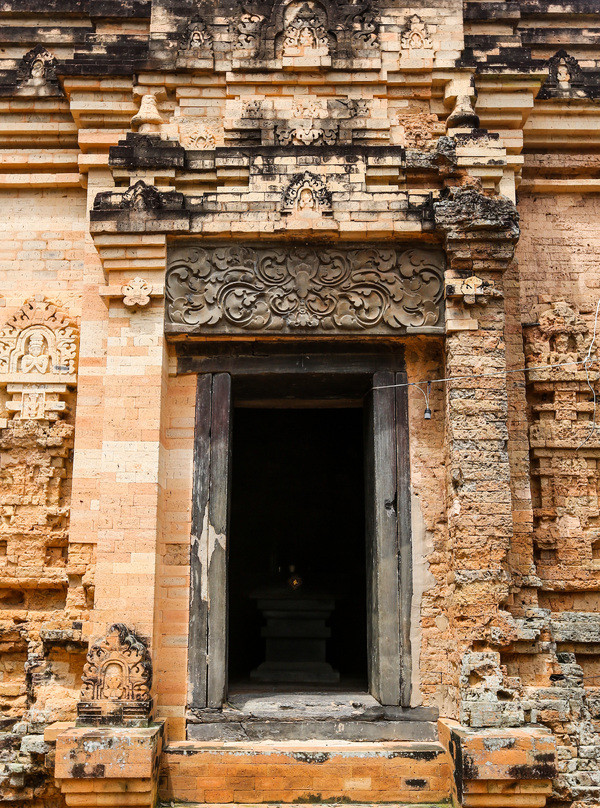 Cửa chính được xây nhô hẳn ra ngoài, rộng 1 m, cao 2 m. Trên cửa chính là một phiến đá lớn, hình chữ nhật, chạm nổi hình hoa cúc cách điệu. Ba mặt Tây - Nam - Bắc đều có cửa giả được đắp nổi các hoa văn, trang trí tinh xảo. Cửa chính được xây nhô hẳn ra ngoài, rộng 1 m, cao 2 m. Trên cửa chính là một phiến đá lớn, hình chữ nhật, chạm nổi hình hoa cúc cách điệu. Ba mặt Tây - Nam - Bắc đều có cửa giả được đắp nổi các hoa văn, trang trí tinh xảo.