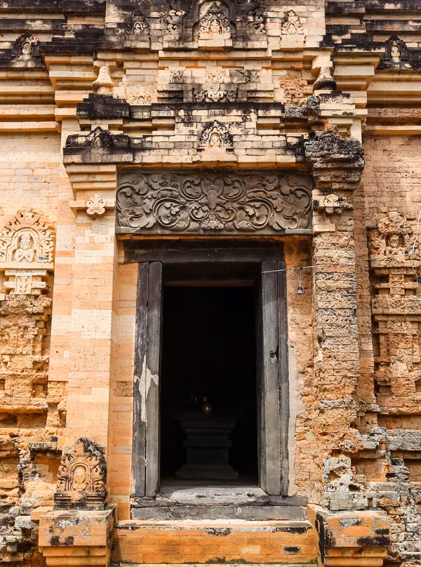 Cửa chính được xây nhô hẳn ra ngoài, rộng 1 m, cao 2 m. Trên cửa chính là một phiến đá lớn, hình chữ nhật, chạm nổi hình hoa cúc cách điệu. Ba mặt Tây - Nam - Bắc đều có cửa giả được đắp nổi các hoa văn, trang trí tinh xảo.