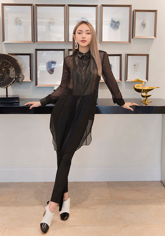  Trong một bức ảnh khác, nàng fashionista diện sơ mi dáng dài mỏng bằng voan đen kết hợp với chi tiết thân áo bằng lụa, quần tây skinny và đôi ankle bốt trắng đen.