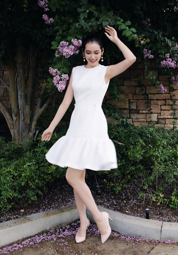 Trúc Diễm xinh xắn với set đồ ton-sur-ton trắng cho đầm hạ eo, giày cao gót, hoa tai ngọc trai hợp trend.
