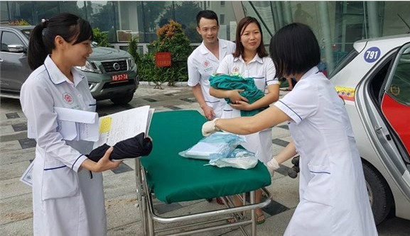  Bác sĩ đón em bé từ taxi. Ảnh: Bệnh viện cung cấp.