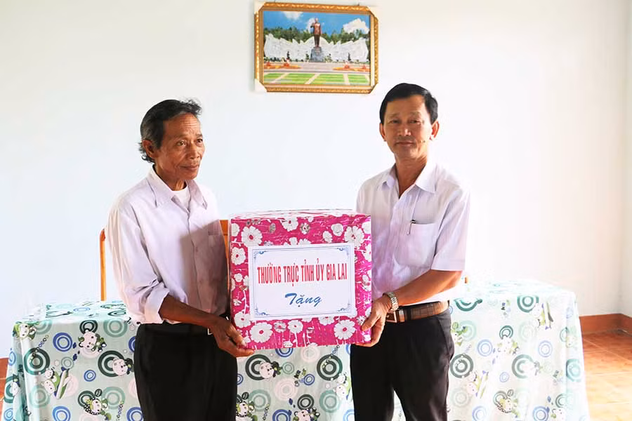 Bí thư Tỉnh ủy Dương Văn Trang (bìa phải) tặng quà cho hệ thống chính trị làng Kon Mahar. Ảnh: Q.T
