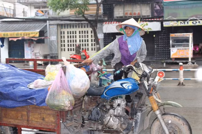 Vì con, người phụ nữ này không ngại vất vả mưu sinh với chiếc xe ba gác. ẢNH: QUANG VIÊN