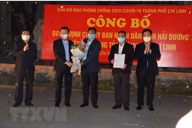 Lãnh đạo tỉnh Hải Dương trao quyết định của Ủy ban Nhân dân tỉnh về gỡ bỏ phong tỏa thành phố Chí Linh. (Ảnh: Mạnh Minh/TTXVN)