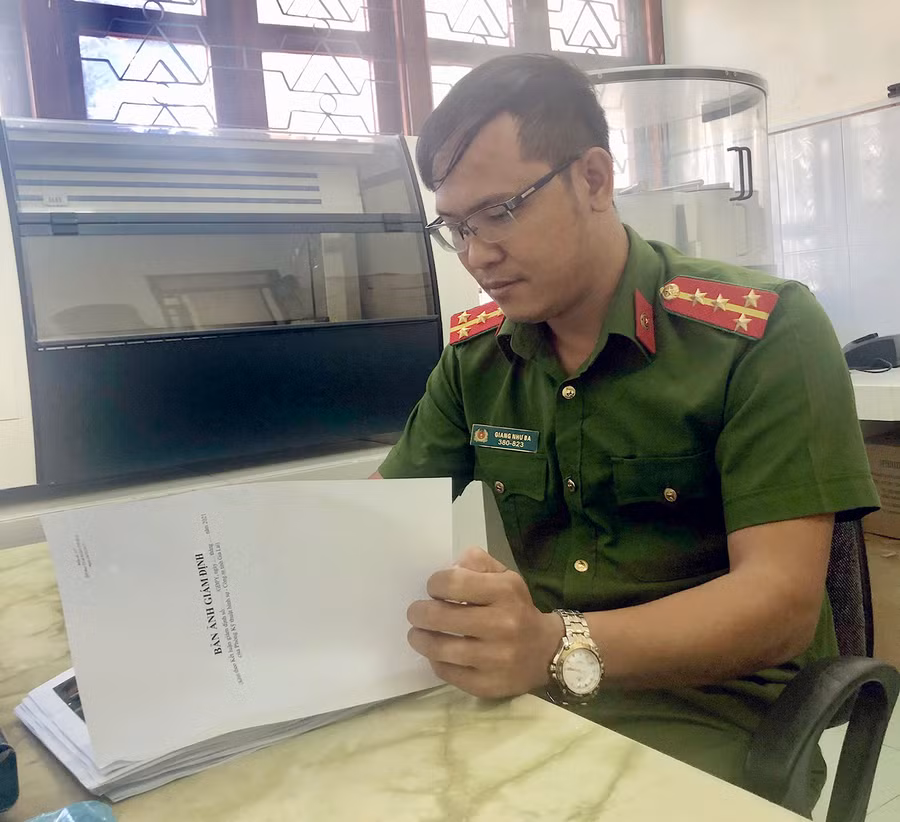 Bác sĩ-Đại úy Giang Như Ba nghiên cứu bản ảnh giám định pháp y. Ảnh: Thúy Trinh