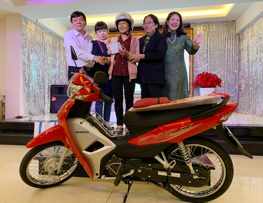 Bà Kpă H’Bin (ở giữa; thôn Pleilok, xã Ia Ke, huyện Phú Thiện) được nhà tài trợ trao tặng xe gắn máy để có phương tiện đi lại trong công tác chăm sóc sức khỏe sinh sản tại cộng đồng. Ảnh: Như Nguyện