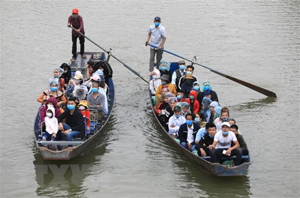 Du khách đi đò vào chùa Hương đều phải đeo khẩu trang phòng chống dịch. (Ảnh: Thành Đạt/TTXVN) Du khách đi đò vào chùa Hương đều phải đeo khẩu trang phòng chống dịch. (Ảnh: Thành Đạt/TTXVN)