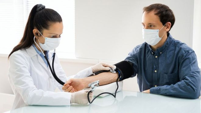 Bác sĩ đo huyết áp cho bệnh nhân. Ảnh: SHUTTERSTOCK