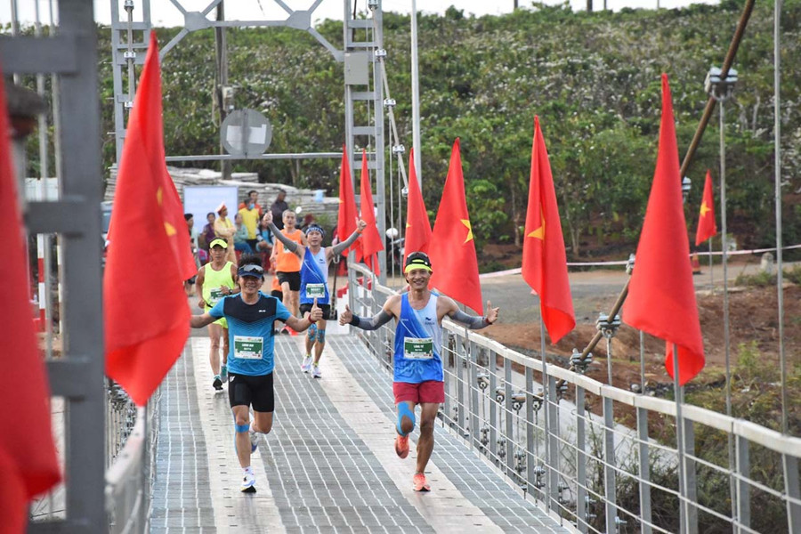 Các vận động viên vui vẻ tạo dáng khi chạy qua cầu treo Biển Hồ. Ảnh: Đức Thụy 10